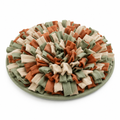 Imagen conceptual de una alfombra olfativa verde, beige y terracota sobre fondo blanco